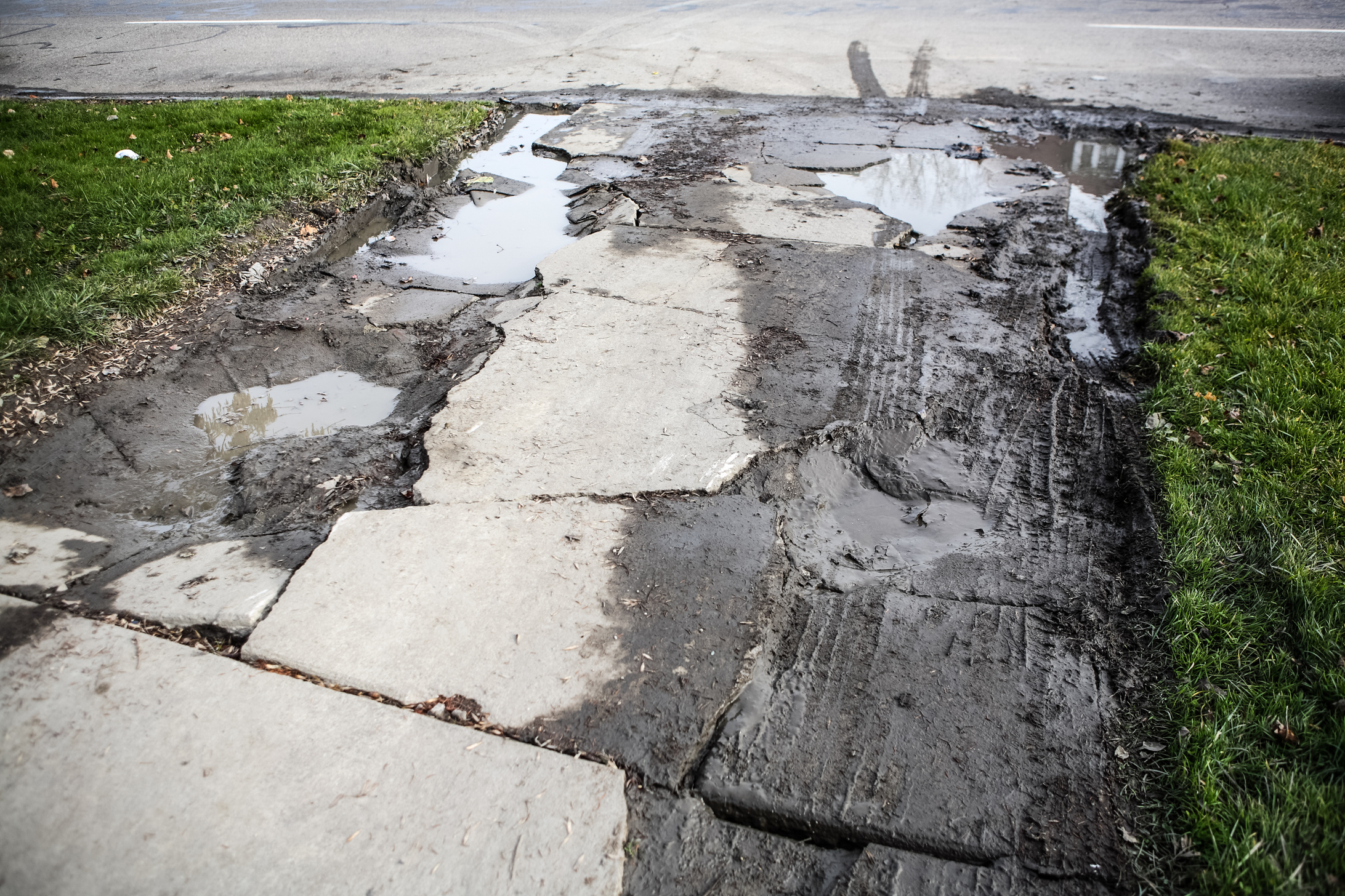 Broken Damaged Cement Driveway with Puddles